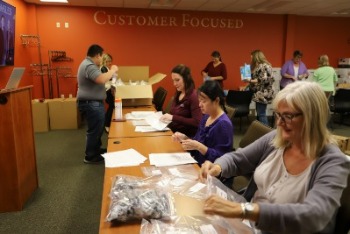 Employees at Peoples volunteering their time packing food for students