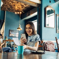 Woman with cellphone taking photo of check