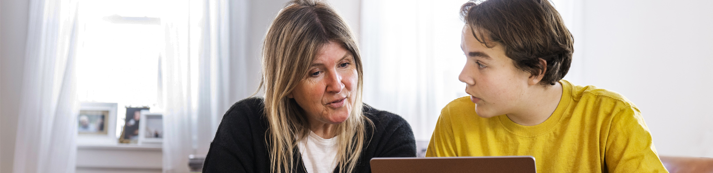 mom and teen son looking at computer