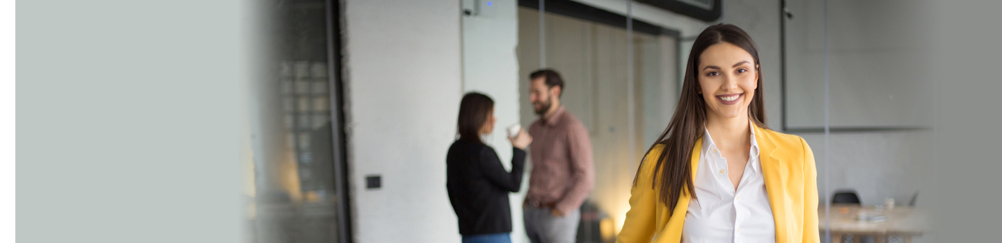 Woman in yellow sweater in front of two colleagues
