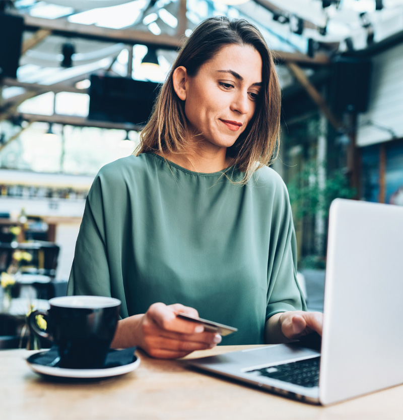 Woman with debit card looking at computer screen