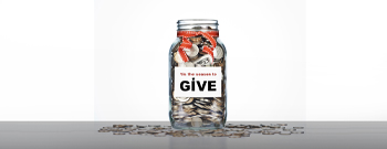 jar on counter with coins and sign that says give