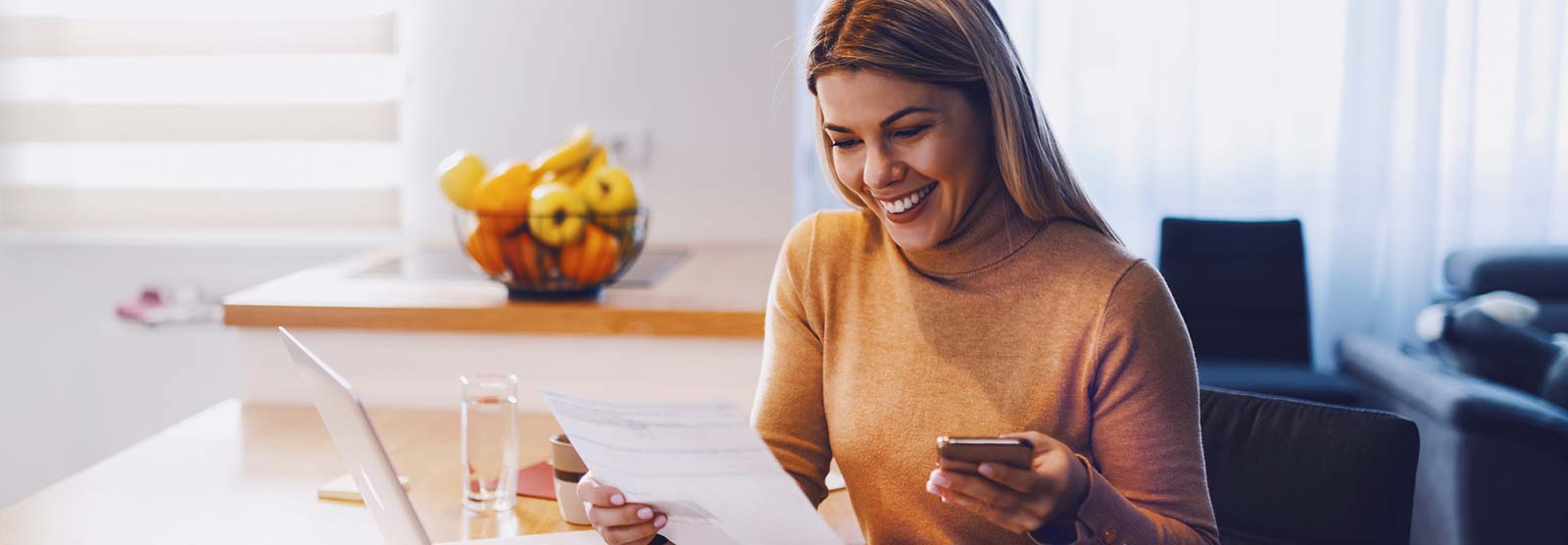 Lady looking at finances with a laptop and mobile phone