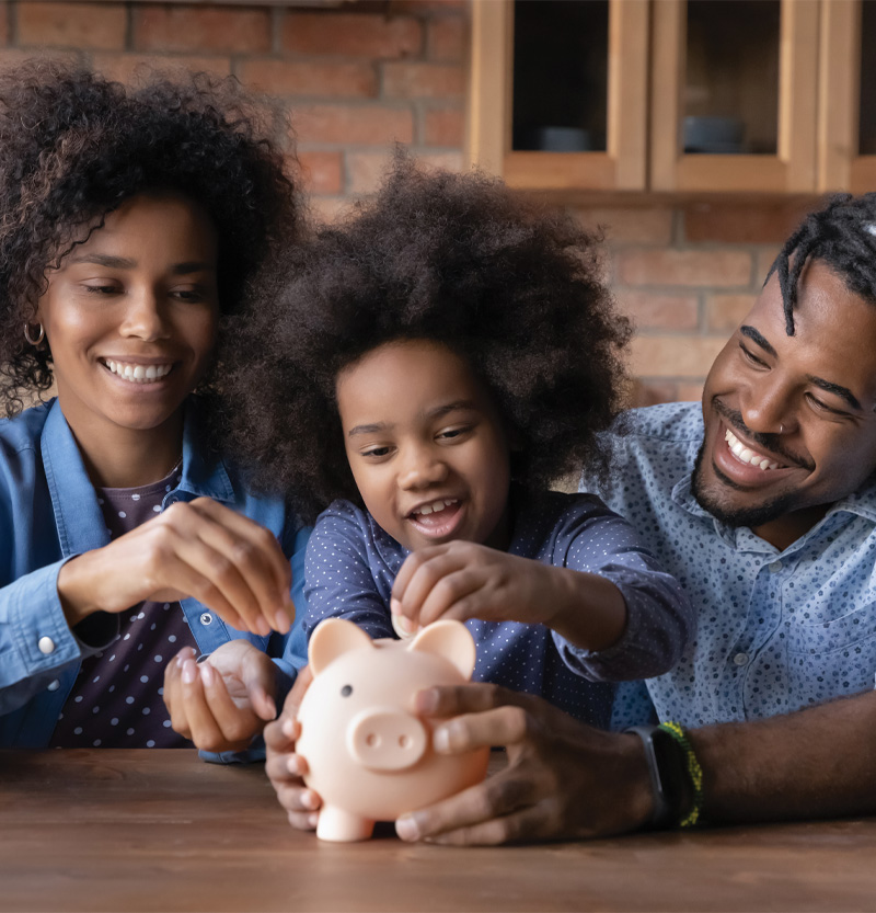 family putting money in piggy bank