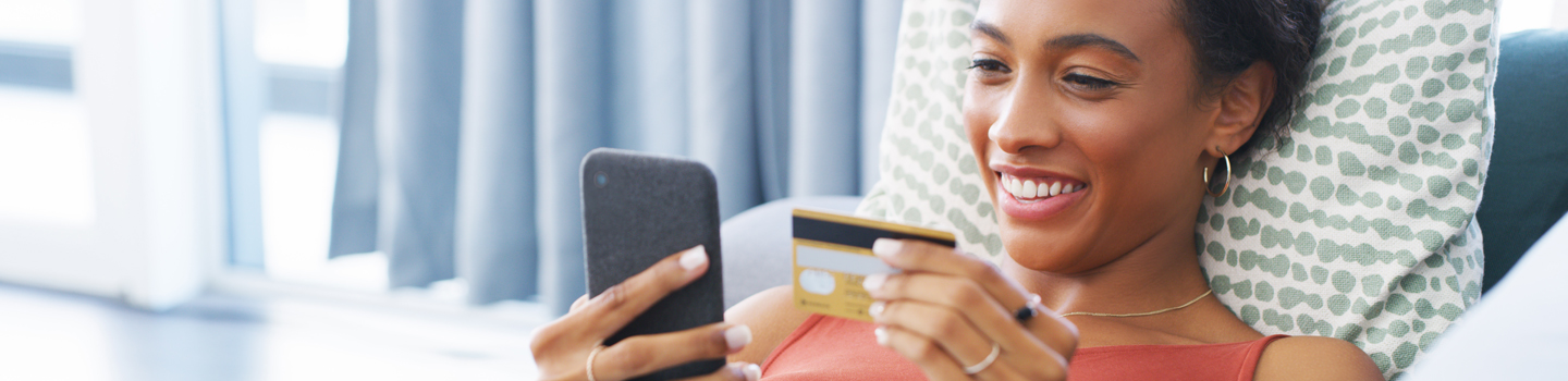 Woman shopping with credit card on cell phone