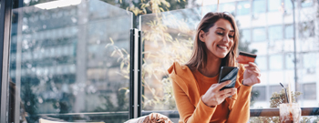 Woman shops with phone and credit card