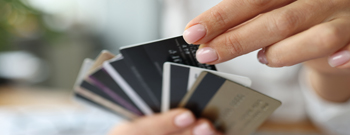 Woman picks credit card out of many cards she's holding